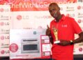 Milano-Marathon-champion-Titus-Ekiru-poses-with-his-dummy-cheque-trophy-and-LG-reward-after-being-awarded-as-the-May-Sports-Personality-of-the-Month.-Photo-SJAK.jpg